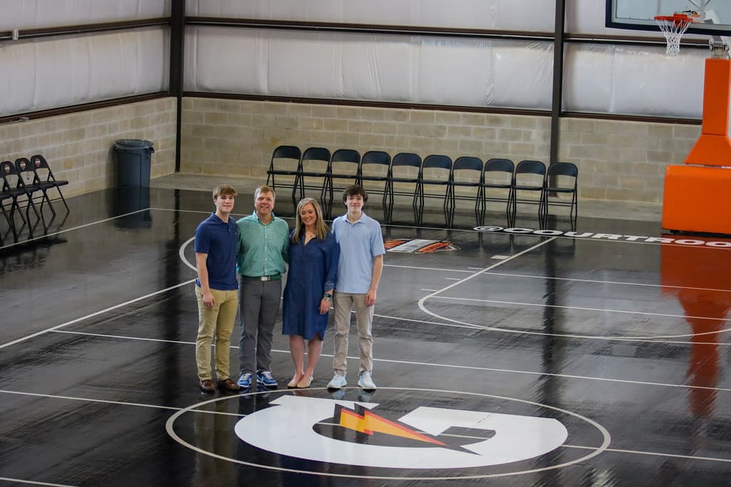 The Drumwright family standing at center court inside The Gatorade Fieldhouse — the people behind the mission.
