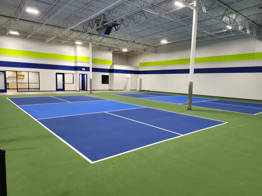 Eleven dedicated indoor pickleball courts at The Fieldhouse, blue and green coated with bright lighting
