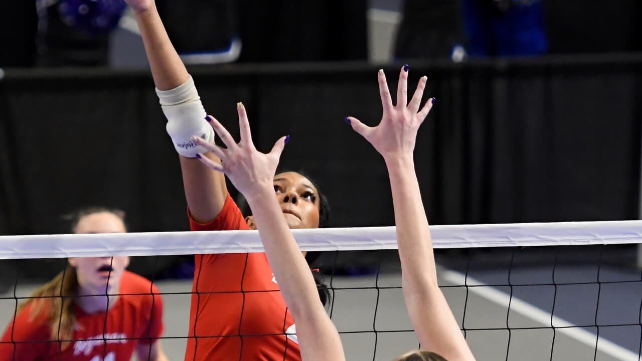 Outside hitter going up for a block at the net during match play