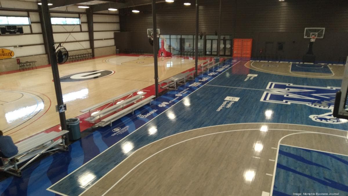 Wide view of the hardwood and blue-coated courts under the Fieldhouse roof